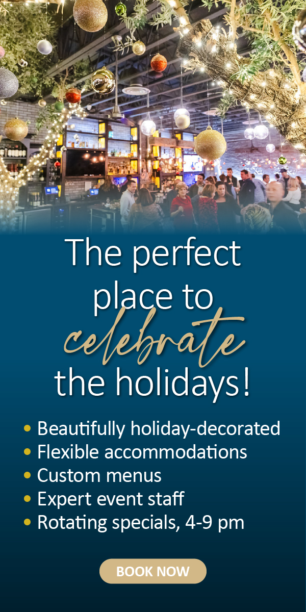 Holiday-decorated event space with people mingling and festive lights, promoting holiday celebrations.