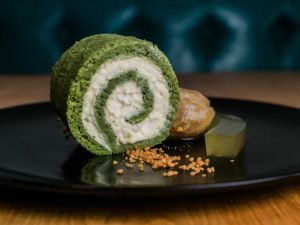 green and white food roll on a black plate